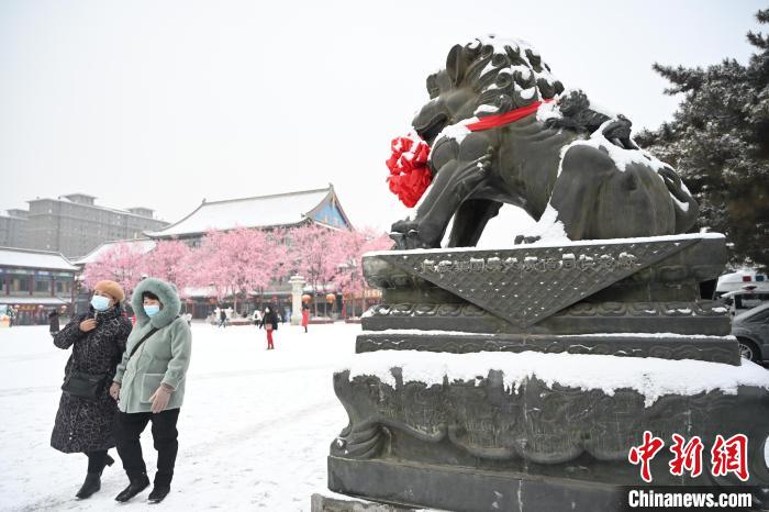 2月13日，民眾在呼和浩特市大召?gòu)V場(chǎng)雪中漫步。　劉文華 攝