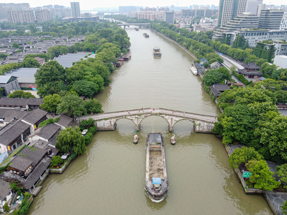 5月27日，一艘貨船駛過(guò)京杭大運(yùn)河南端標(biāo)志建筑杭州拱宸橋。(無(wú)人機(jī)照片)新華社記者江漢 攝