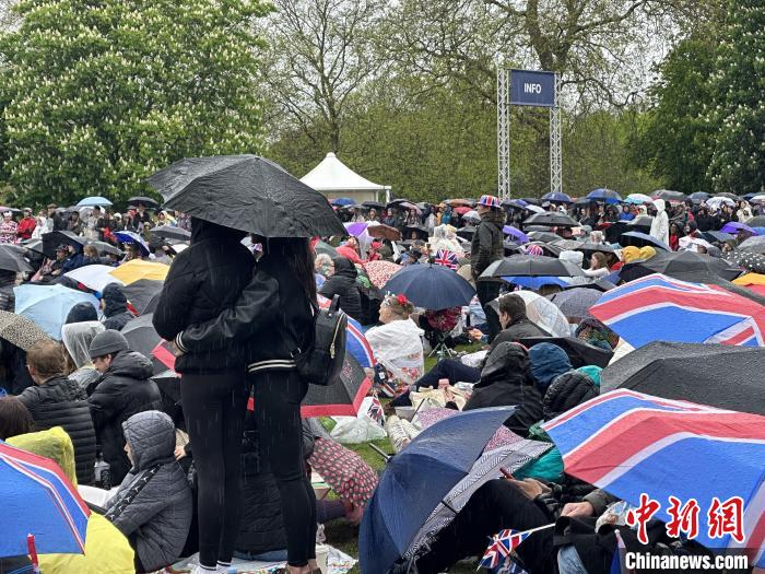 當?shù)貢r間5月6日，英國國王查爾斯三世的加冕儀式舉行。民眾雨中觀看儀式。　歐陽開宇 攝