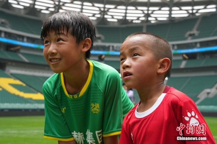 圖為北京國安小球員陳小北和7歲的俄金仁增在一起觀看場內播放的紀錄片。<a target='_blank' href='/' _fcksavedurl='/'><p  align=