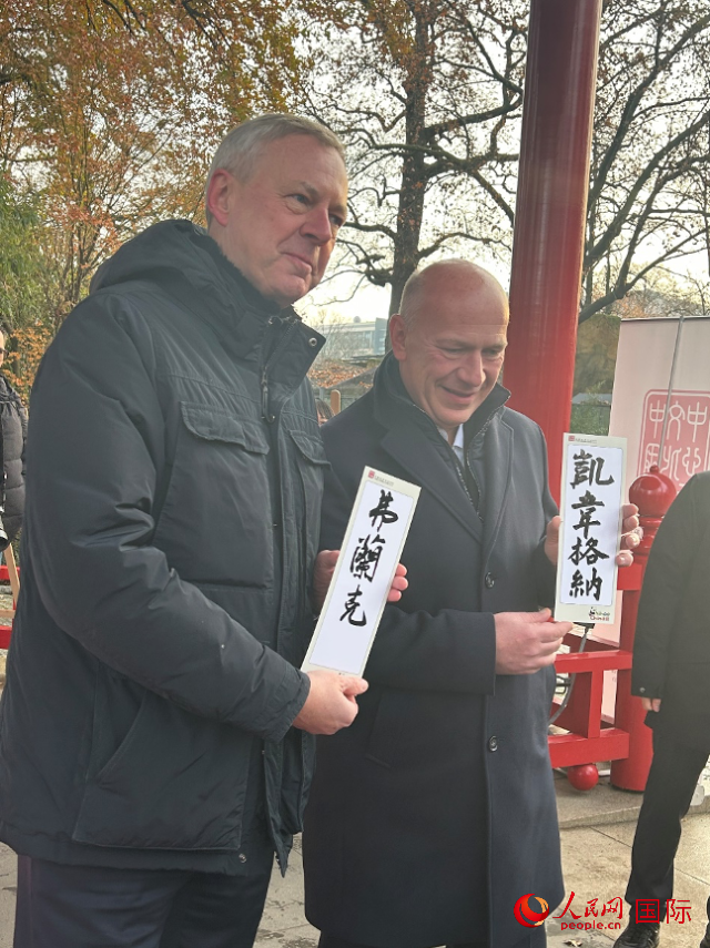 柏林市長(zhǎng)韋格納（右）、動(dòng)物園監(jiān)事會(huì)主席布魯克曼（左）手持中國(guó)文化中心工作人員現(xiàn)場(chǎng)手書(shū)的中文名字。人民網(wǎng)記者 徐馨攝