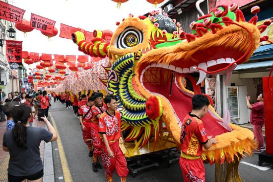 2月1日，由馬來西亞和中國的100多名青少年組成的舞龍隊在馬來西亞馬六甲市雞場街上共舞一條近200米的“長龍”。這是活動現(xiàn)場的“長龍”。新華社記者程一恒攝