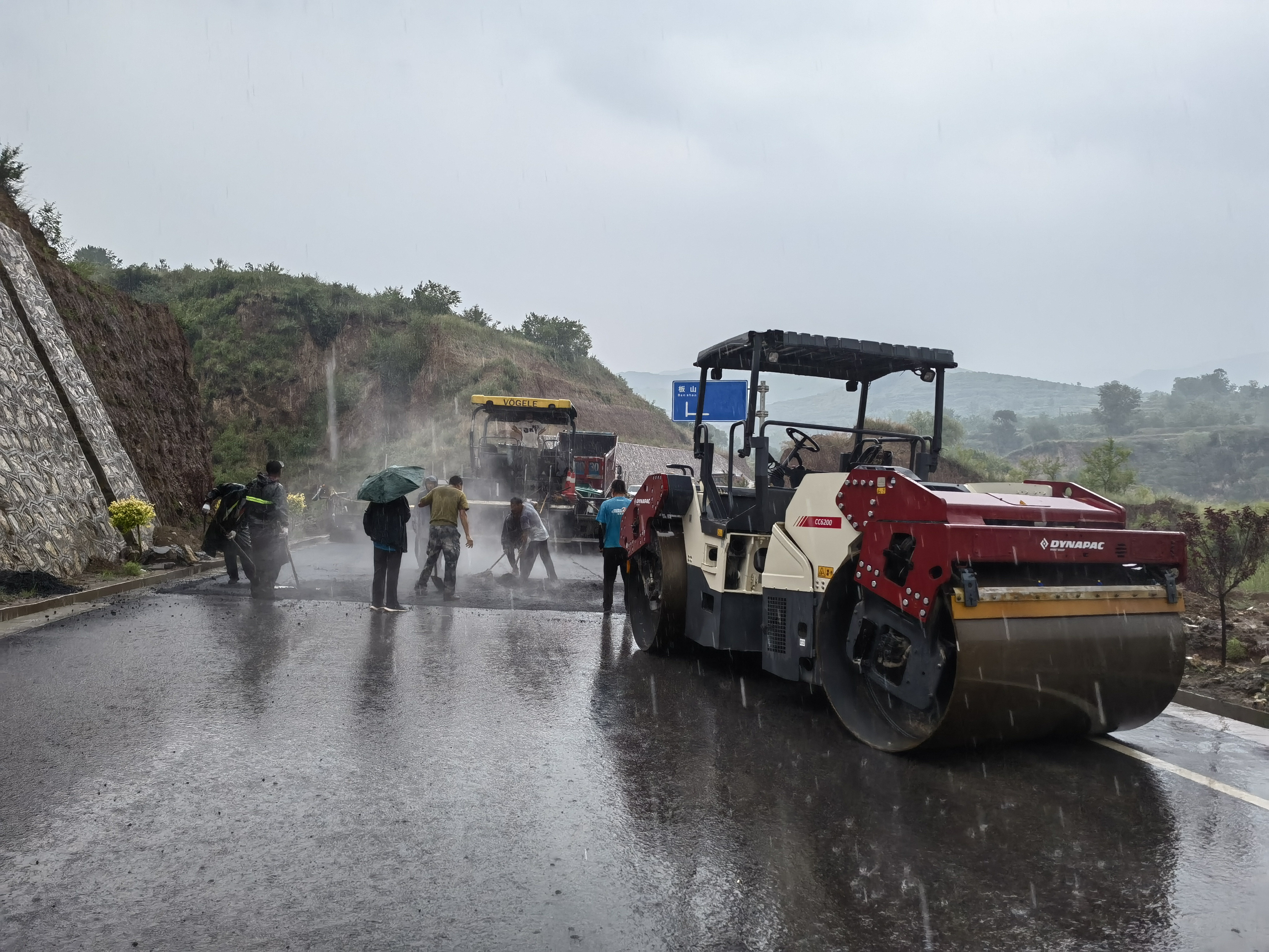 路橋工人在大雨中搶修道路。李華英 攝