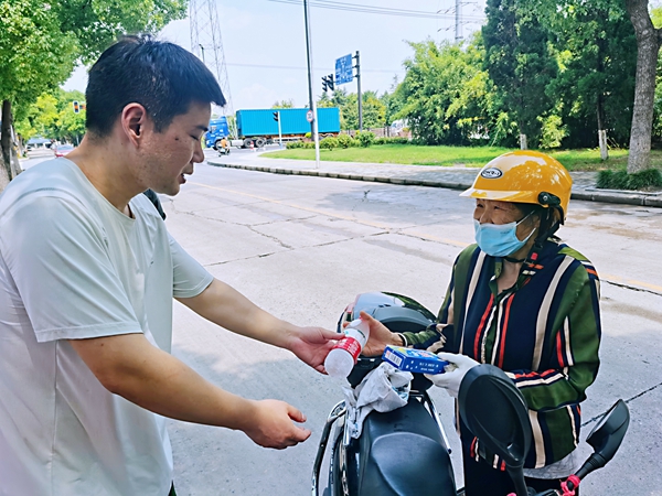 何超為過路的老人送上礦泉水和冷飲。人民網(wǎng)記者 王繼亮攝