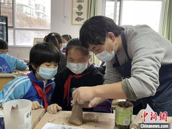 圖為西寧市勞動路小學(xué)教師賈煜與學(xué)生一起制作陶藝?！≈苋鸪阶?攝