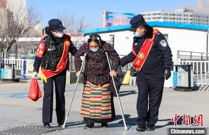 圖為拉薩鐵路公安民警幫助老人進(jìn)站乘車(chē)?！『铲i 攝