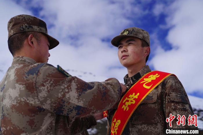 排長(zhǎng)王朝偉(圖左)給退伍老兵佩戴大紅花?！∥鞑厣侥宪姺謪^(qū)某團(tuán)供圖