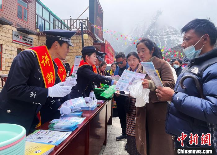 圖為山南玉麥邊境派出所民警為轄區(qū)群眾發(fā)放法律知識(shí)宣傳單?！＄婗?　攝