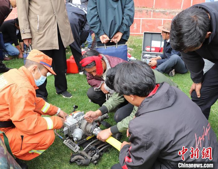 圖為森林消防員為護林員講解滅火裝備的使用方法?！〔际猩窒乐ш?供圖