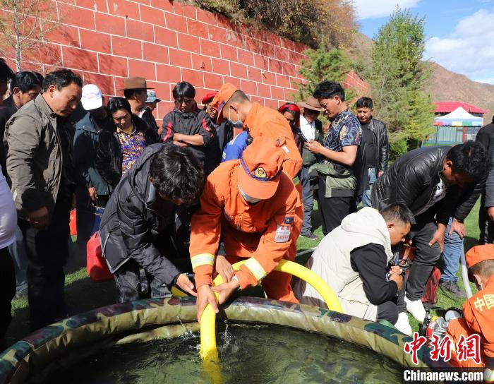 圖為森林消防員為護林員講解滅火裝備的使用方法?！〔际猩窒乐ш?供圖