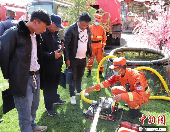 圖為森林消防員為護林員講解滅火裝備的使用方法?！〔际猩窒乐ш?供圖