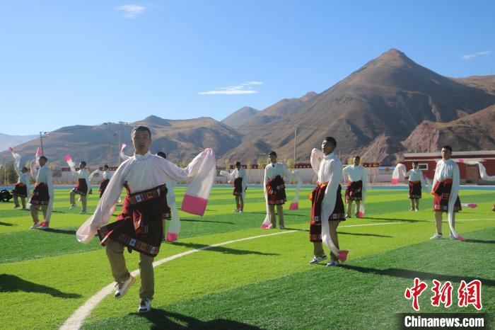 圖為青海師范大學(xué)附屬玉樹實驗學(xué)校學(xué)生在綠茵場跳起囊謙古舞—卓根瑪。　程雨 攝