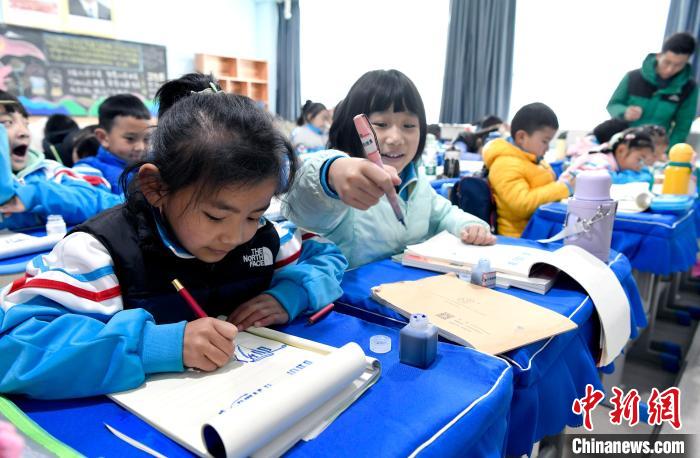 3月14日，西藏拉薩市第一小學(xué)一年級六班學(xué)生白瑪朗珍(圖左)在藏語文課上書寫藏文?！±盍?攝