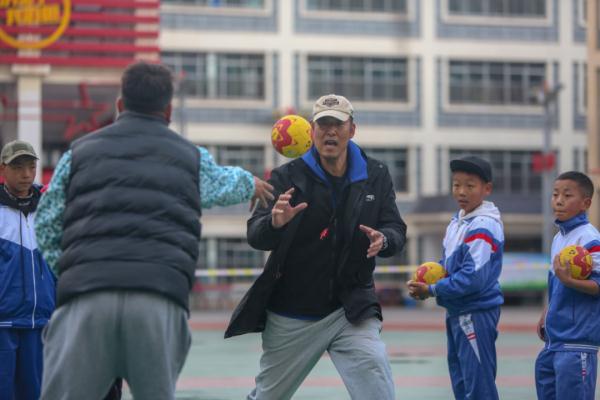 在高原上教孩子們打手球，“慢慢兒來，甭著急！”