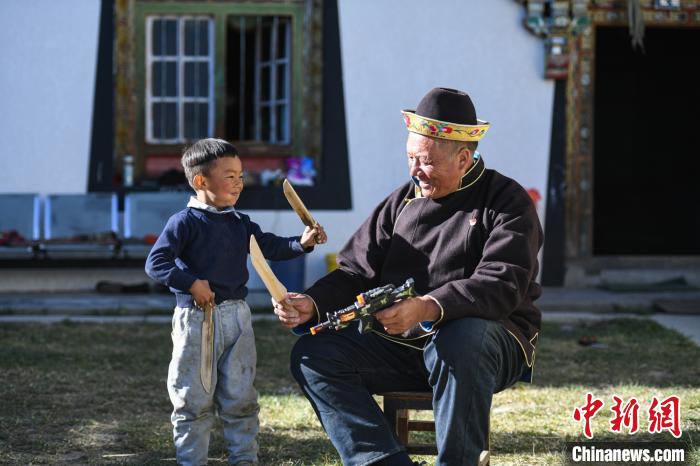 圖為米林縣扎西繞登鄉(xiāng)彩門村64歲的洛桑帶著孫子巴桑在院子的草地上玩耍?！『闻罾?攝