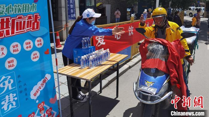 圖為近日，西藏自治區(qū)青年志愿者協(xié)會(huì)志愿者在拉薩街頭向快遞員送水。西藏自治區(qū)青年志愿者協(xié)會(huì) 供圖