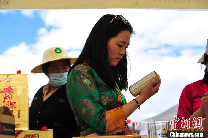 圖為拉薩市民在特色農(nóng)畜產(chǎn)品展示展銷會(huì)上選購(gòu)商品?！垈?攝