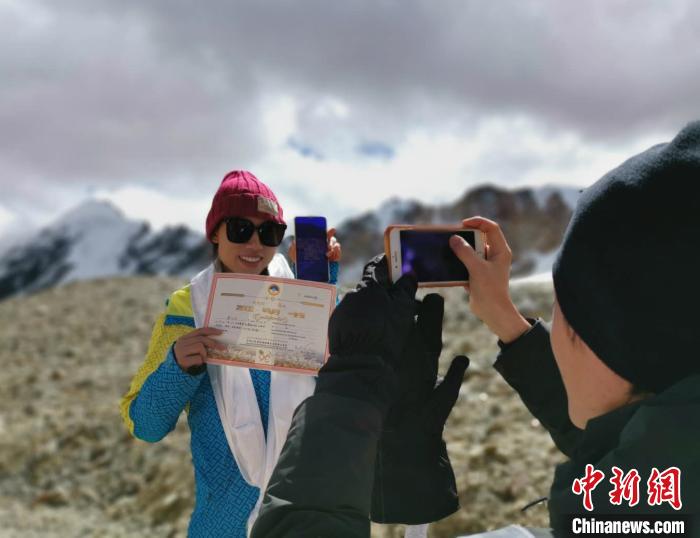 圖為5日，登頂洛堆峰的登山者獲得西藏自治區(qū)登山協(xié)會頒發(fā)的登頂證明?！垈?攝