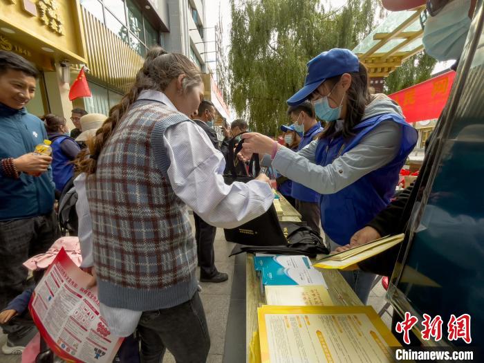 圖為志愿者為市民發(fā)放網(wǎng)絡安全宣傳手冊?！≈x牧 攝