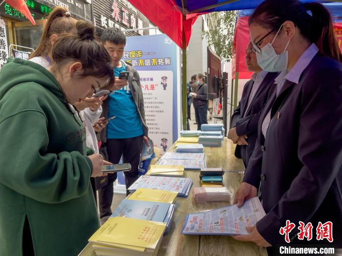 圖為工作人員正在向路過市民介紹國家反詐中心軟件的功能。　謝牧 攝