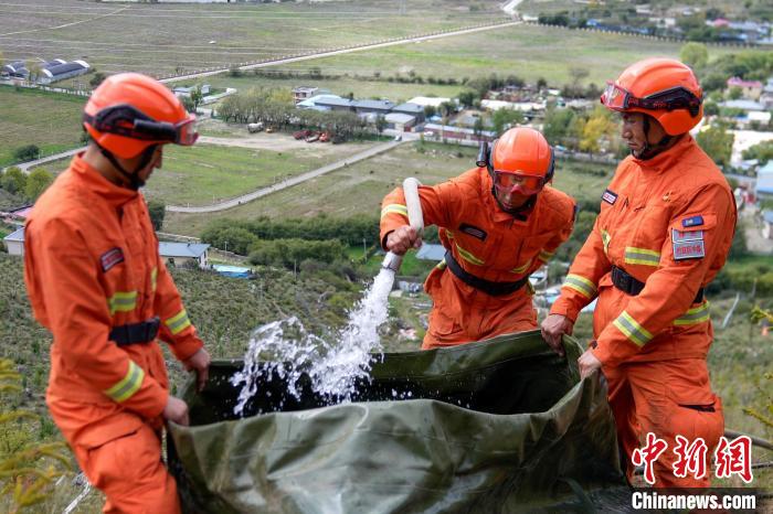 技能大練兵過程中，消防員在陡坡上向蓄水池注水?！±顕鵂c 攝