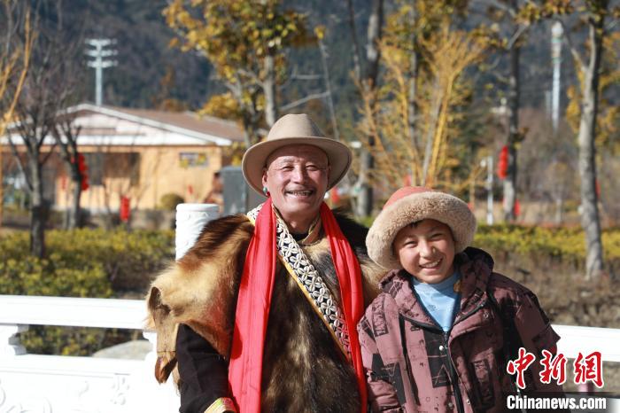 圖為林芝市巴宜區(qū)布久鄉(xiāng)仲果村村民桑杰與孫子一起參加藏歷新年活動(dòng)?！埩?攝