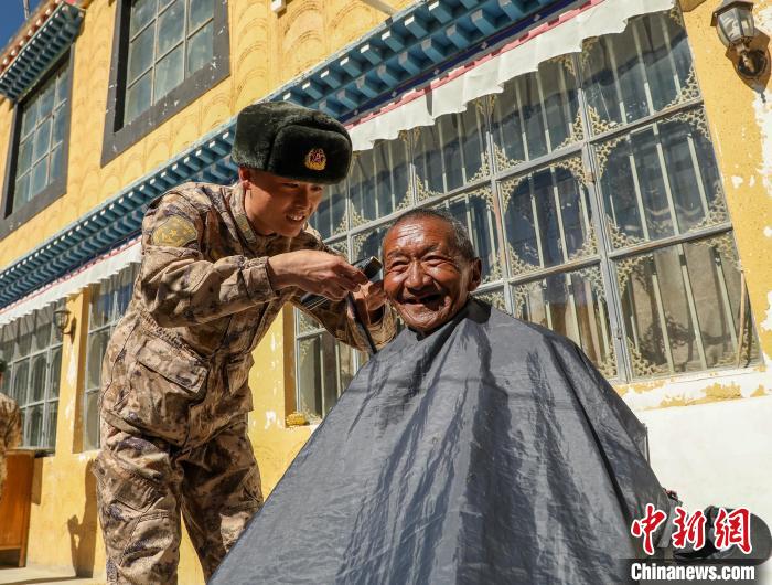 圖為阿里軍分區(qū)某邊防團(tuán)官兵為駐地群眾理發(fā)迎藏歷新年?！〉┰鰝愔?攝