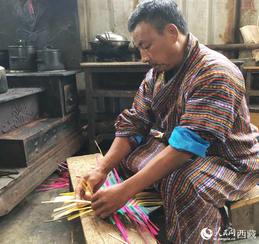 門巴族漢子愛明正在編織藤竹品。